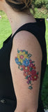 Grand tatouage temporaire de fleurs multicolores de 17 cm porté sur le haut du bras